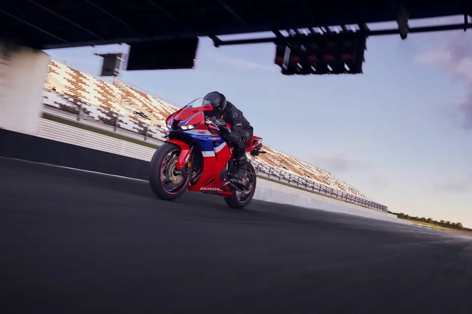Supersport motorcycle Honda CBR600RR on the home straight of a race track beneath a bridge