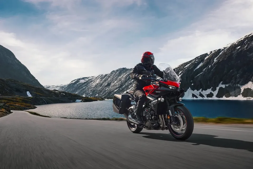 Tourer Honda CB1000GT mit Seitenkoffern auf einer Passstrasse an einem Bergsee